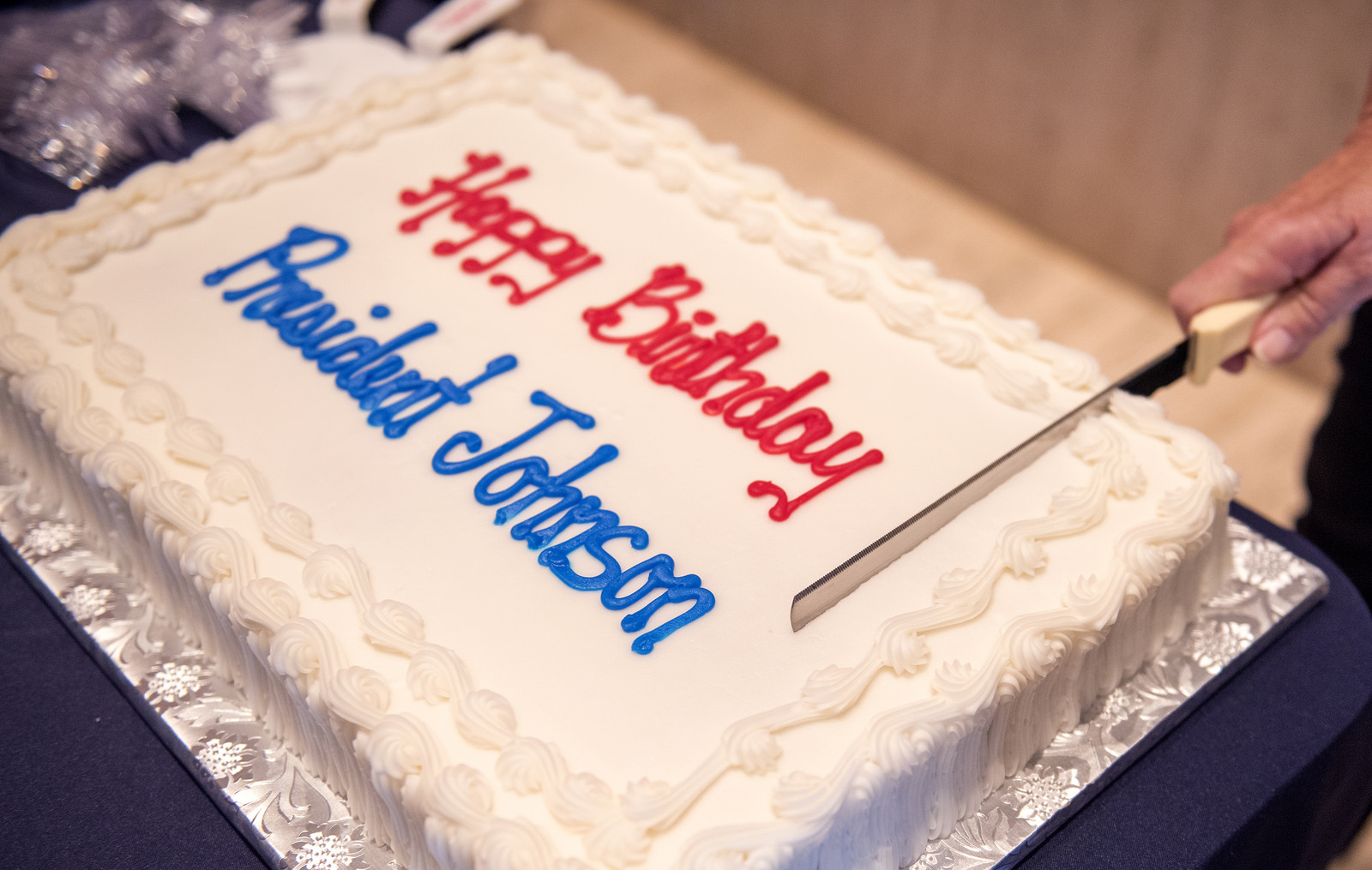 White birthday cake with red and blue LBJ birthday message